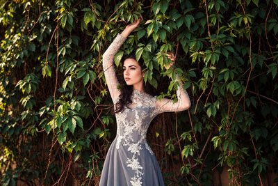 Model in a lace gown against a wall of climbing ivy