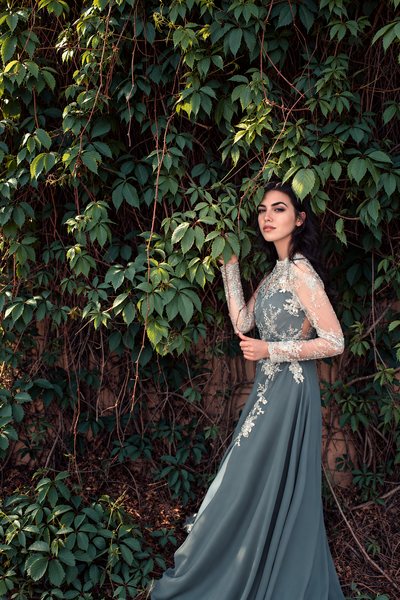 Full-length gown against dense foliage