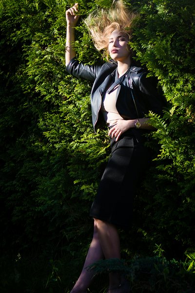 Model in black against dark foliage