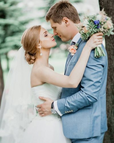 Newlyweds walking through a sunlit meadow
