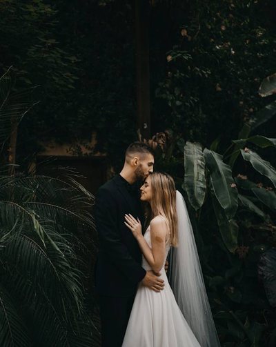 Groom standing in warm window light